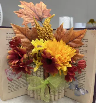 Fall decoration made with old book and silk flowers.