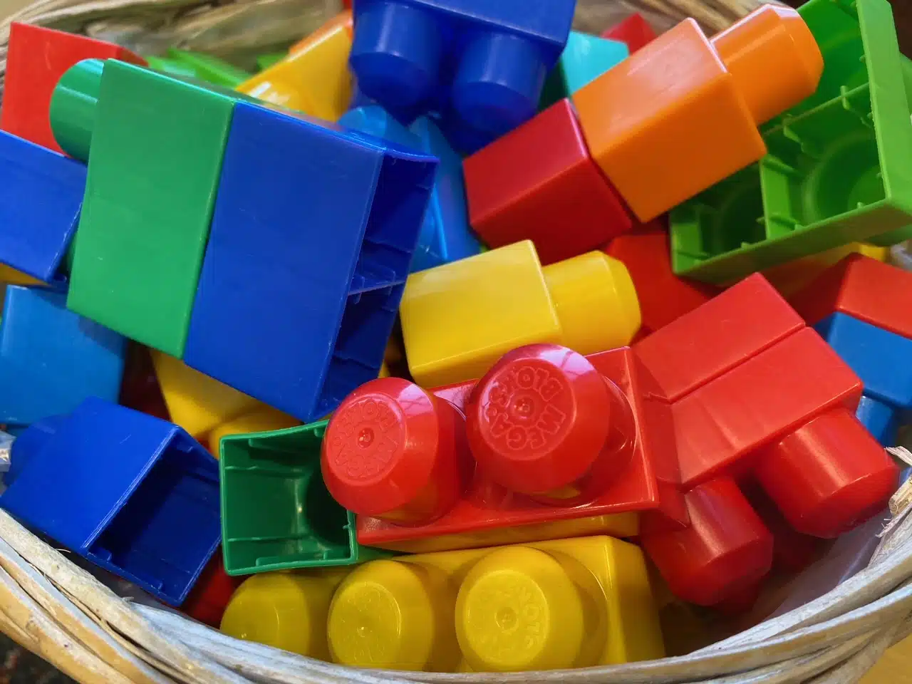 Basket of large brightly colored building blocks.