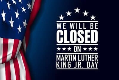 Blue background with U.S. Flag to one side, and white text reading We Will Be Closed On Martin Luther King Jr. Day.
