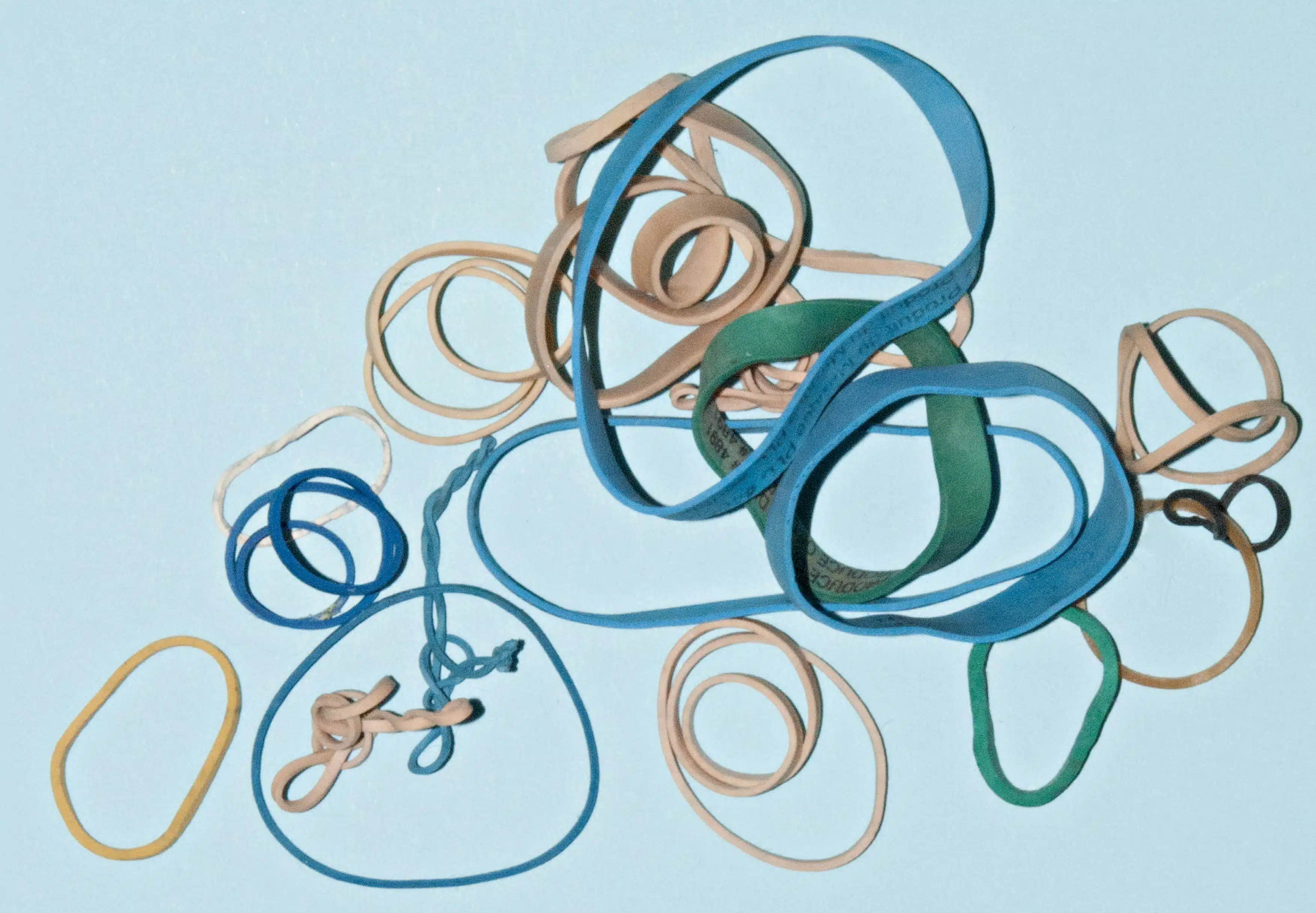 Cluster of green, blue and tan rubber bands.