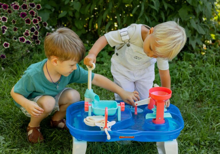 Two young boys playing with a water table toy.
