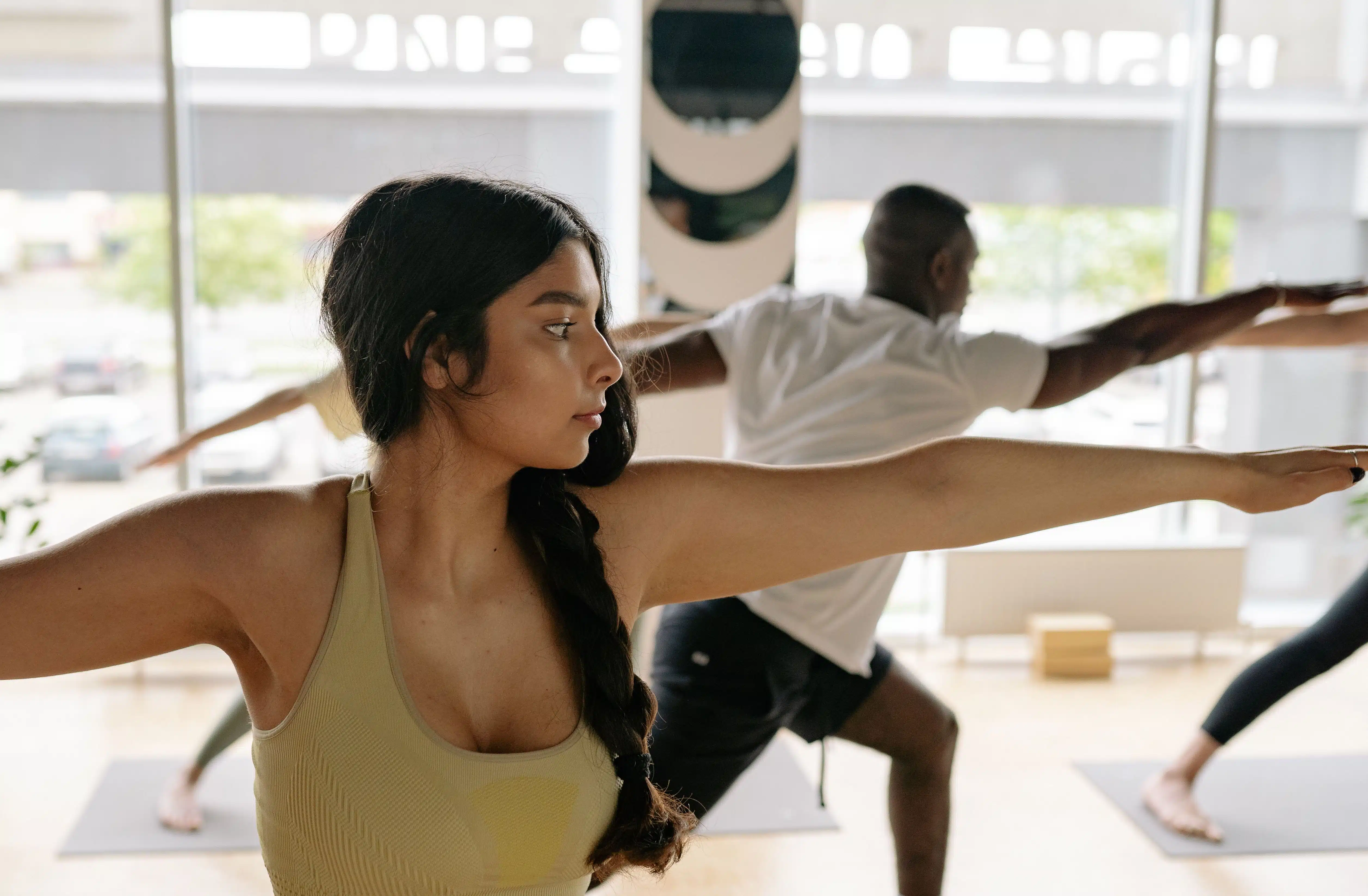 Man and woman doing yoga stretches at class.